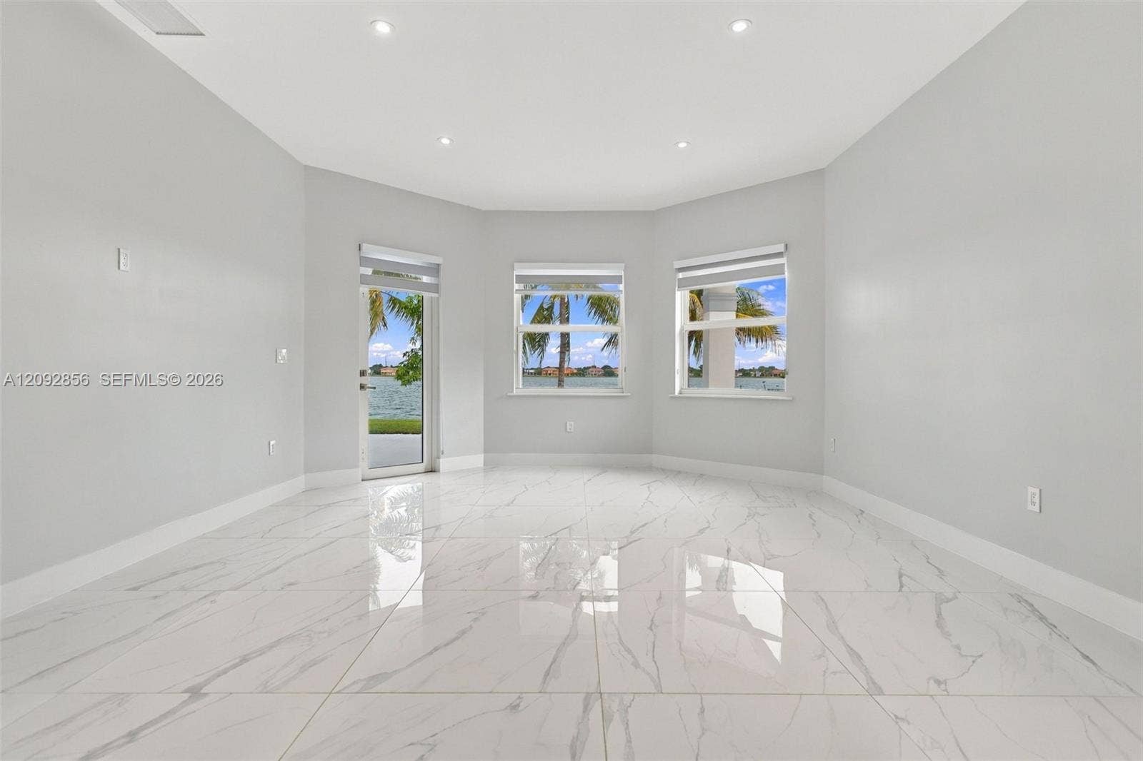 18919 SW 24th Street, #18919, Miramar, Miramar, FL 33029 Spacious room featuring polished tile flooring with a marble-pattern finish, recessed ceiling lighting, a multi-paneled bay window configuration, and a glass-paneled exterior door