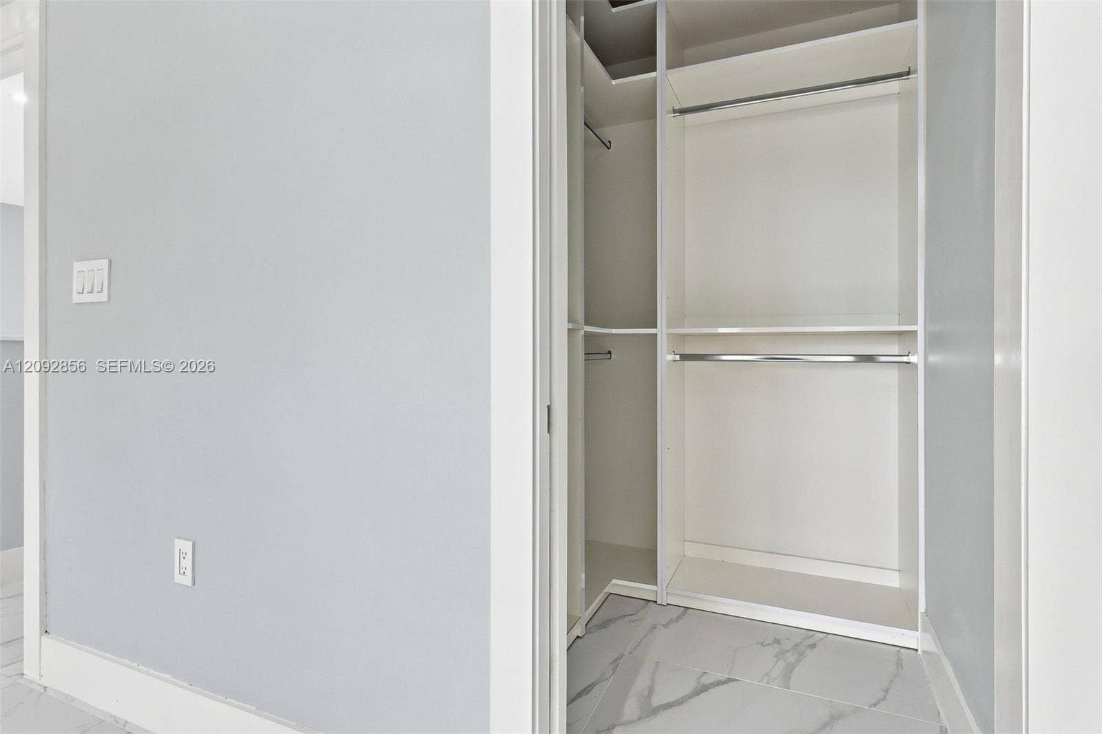 18919 SW 24th Street, #18919, Miramar, Miramar, FL 33029 3rd bedroom Walk-in closet featuring white built-in shelving, dual hanging rods, and large-format porcelain tile flooring with marble-finish veining