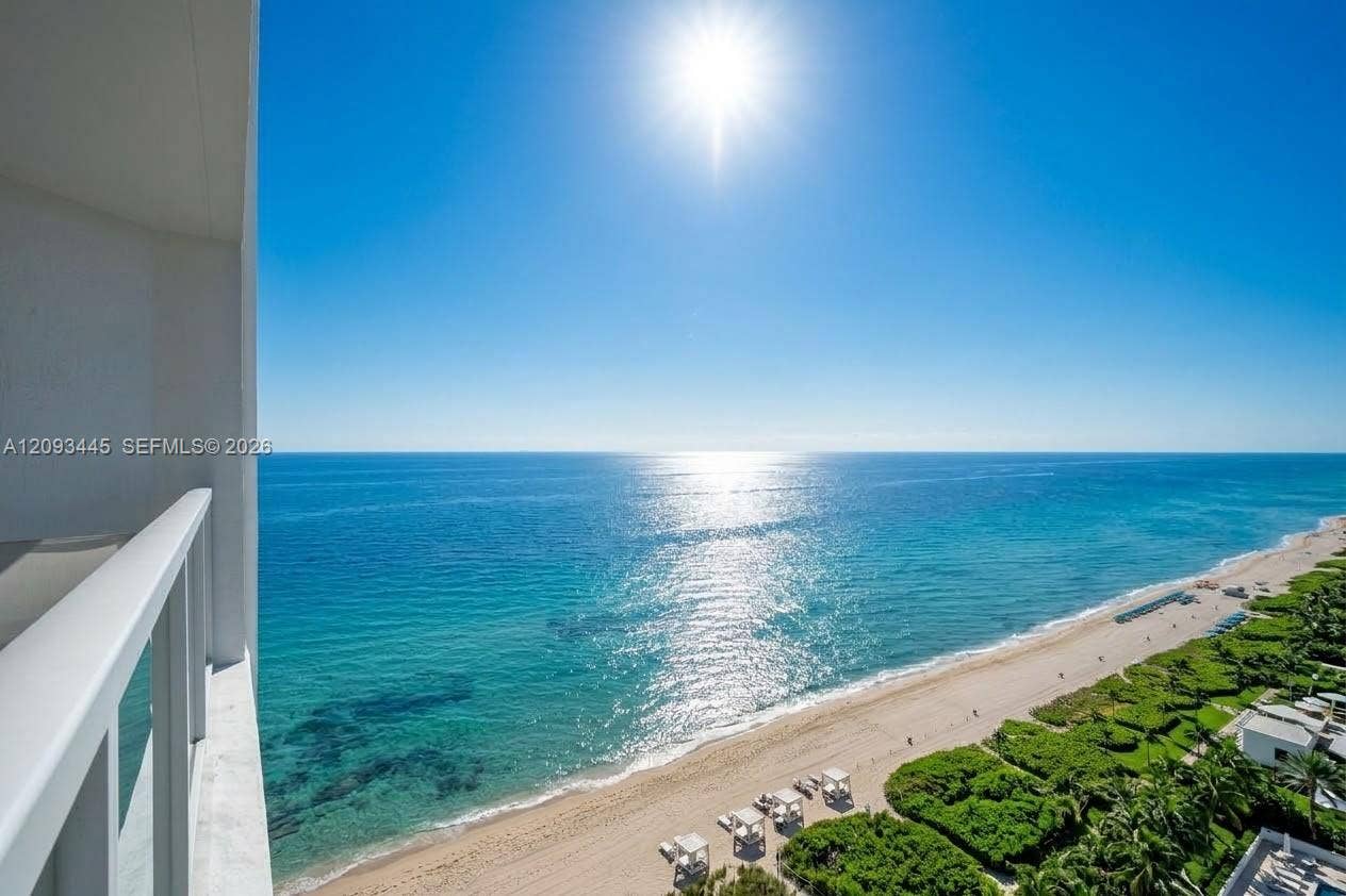 Expansive ocean vista from a private balcony, featuring a sand beach and clear blue waters