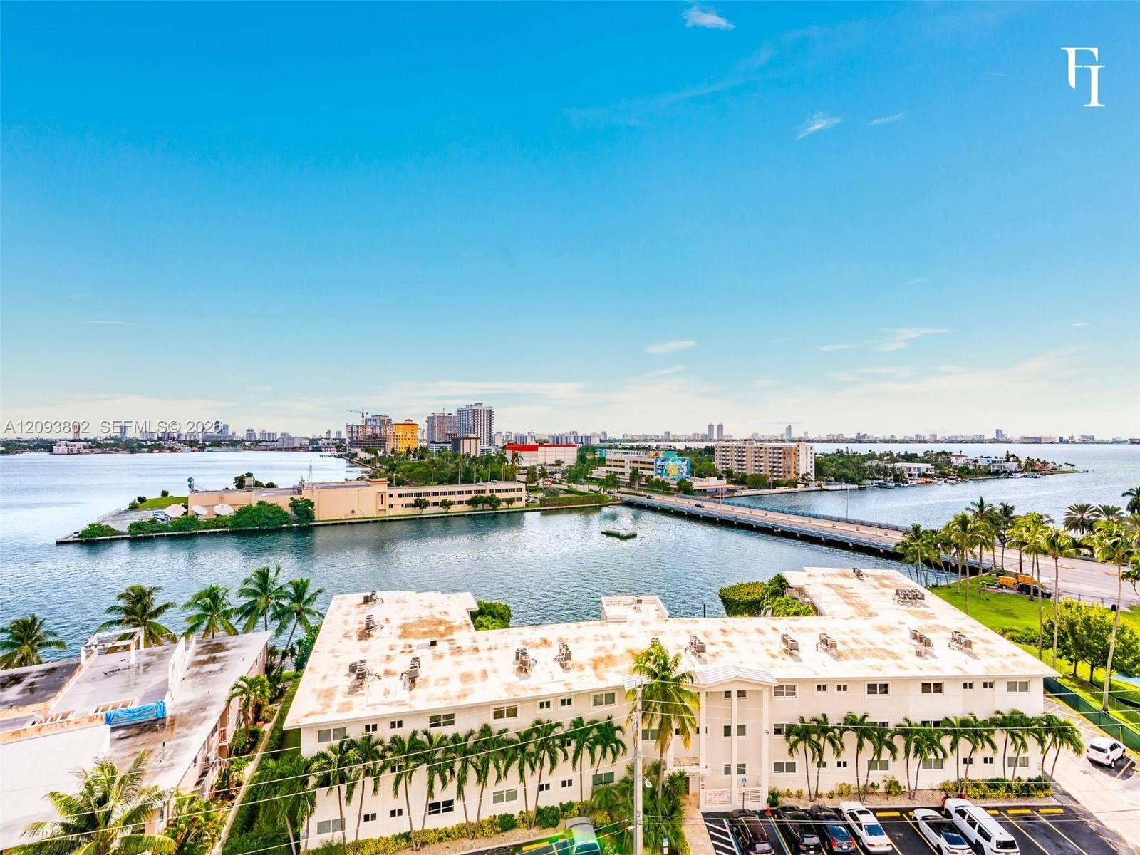 7910 Harbor Island Drive, #909, North Bay Village, North Bay Village, FL 33141 Waterfront property featuring panoramic bay scenery, mature palm trees, exterior parking, and proximity to urban infrastructure