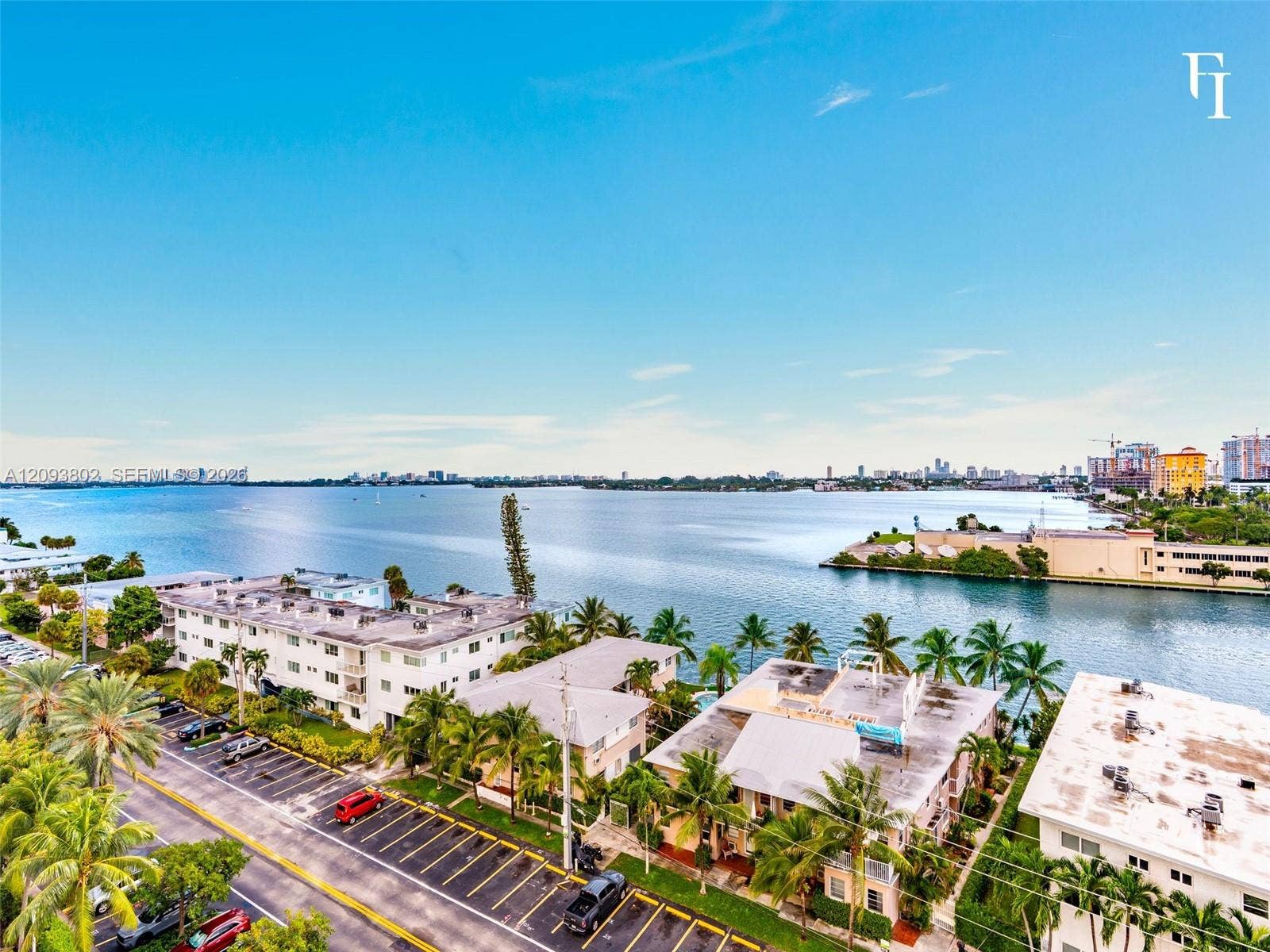 7910 Harbor Island Drive, #909, North Bay Village, North Bay Village, FL 33141 Aerial perspective featuring expansive coastal waterfront, mature palm trees, and established building exteriors