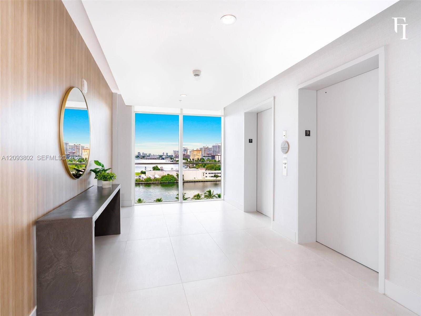 7910 Harbor Island Drive, #909, North Bay Village, North Bay Village, FL 33141 Large-format tile flooring, wood-finish wall paneling, floor-to-ceiling windows with waterfront scenery, and dual elevator access