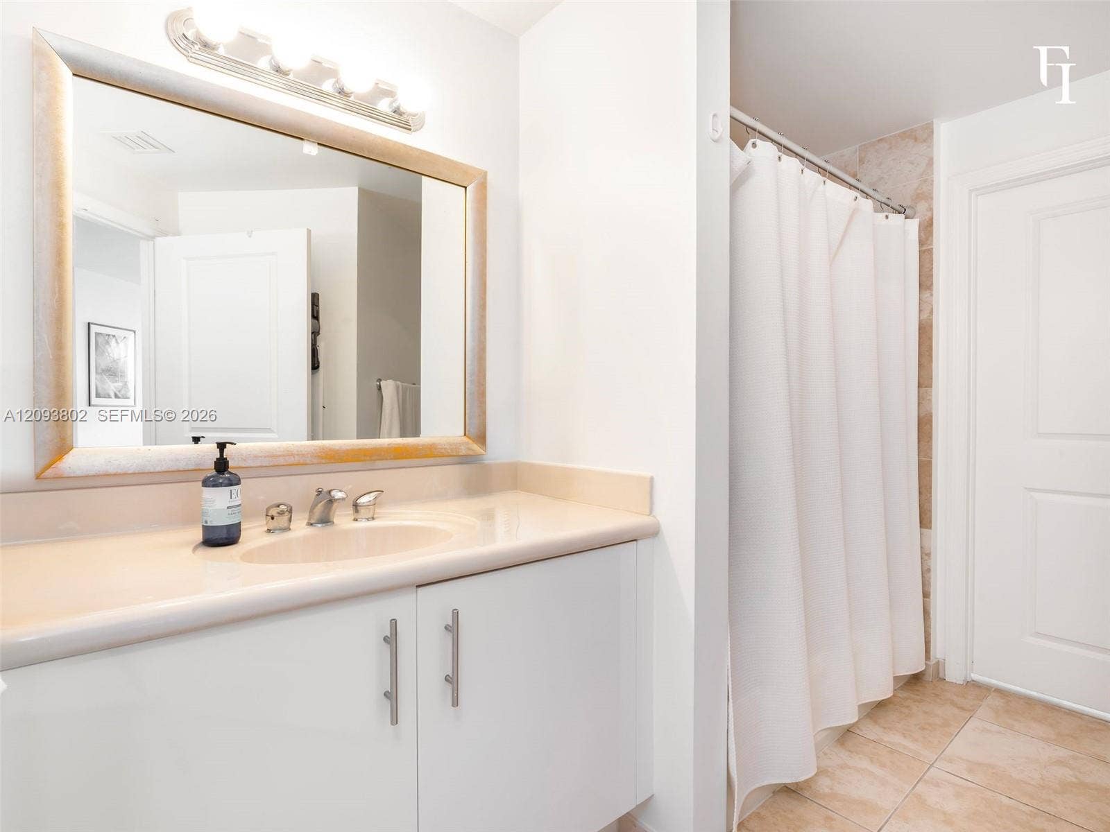 7910 Harbor Island Drive, #909, North Bay Village, North Bay Village, FL 33141 Bathroom featuring a white vanity cabinet with a solid surface countertop, an undermount sink, a framed mirror with integrated lighting, and tile flooring