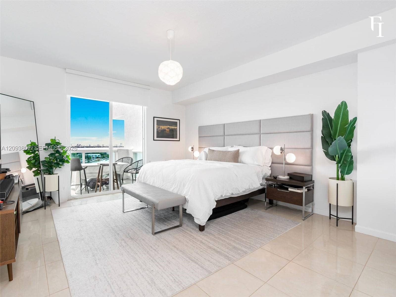 7910 Harbor Island Drive, #909, North Bay Village, North Bay Village, FL 33141 Spacious room featuring light-toned tile flooring, an oversized upholstered wall panel headboard, a modern spherical pendant light fixture, and large glass sliding doors providing external access