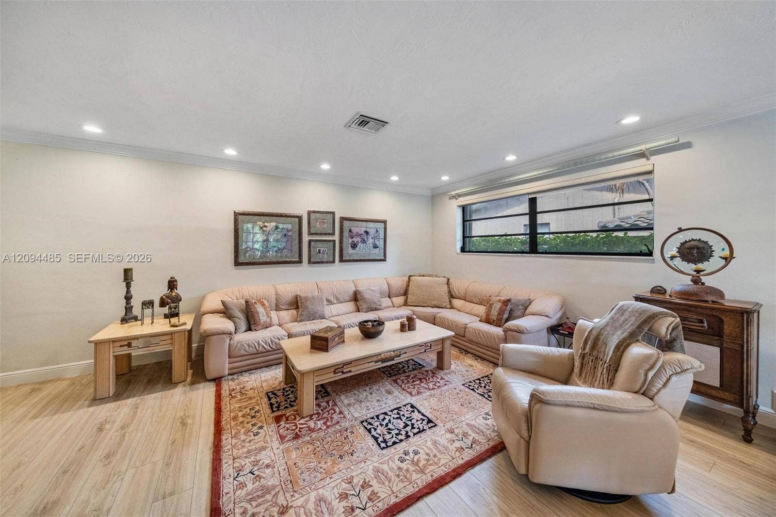 Living area featuring wood-finish flooring, recessed lighting, and a large horizontal window with black-framed horizontal muntins