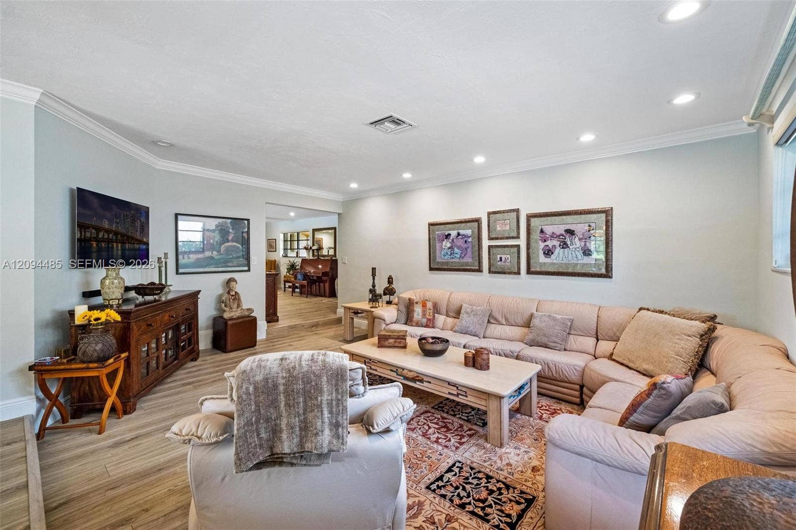 Living area featuring wood-finish flooring, recessed lighting, and crown molding