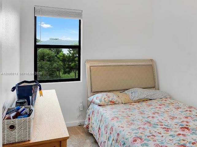 Neutral-toned interior featuring wall-to-wall carpeting and a single-hung window with a horizontal blind