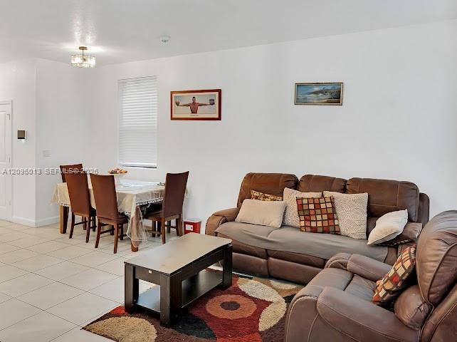 Neutral-toned ceramic tile flooring, clean white wall finishes, and a contemporary multi-bulb ceiling light fixture