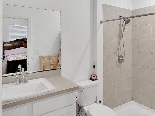 Bathroom featuring a white vanity cabinet, solid-surface countertop with an integrated basin, frameless mirror, and a walk-in shower with neutral tile surround and handheld fixture