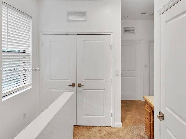 Double doors featuring brushed nickel hardware, horizontal slat window blinds, and solid-core interior doors