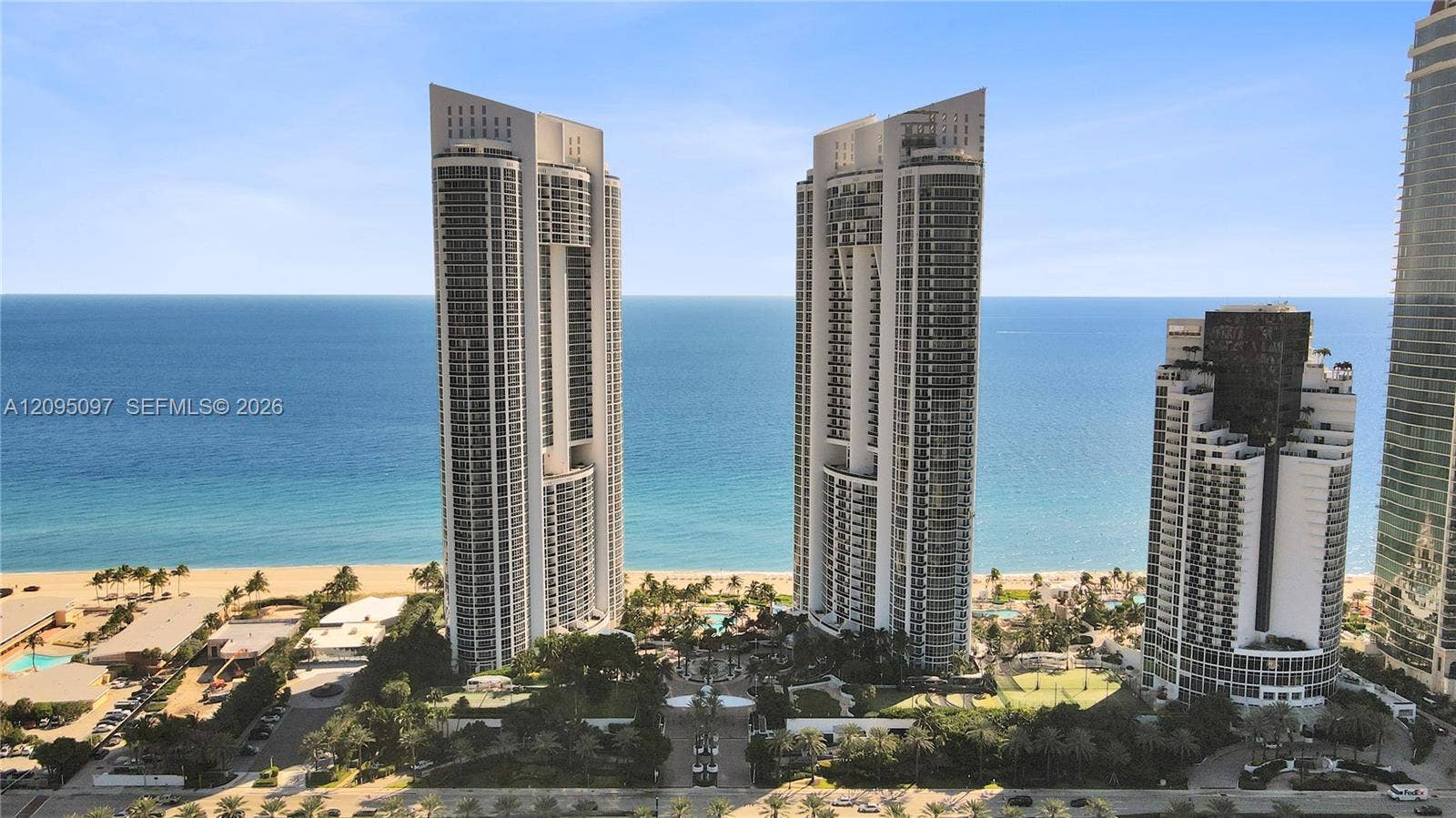 18201 Collins Avenue, #1407, Sunny Isles Beach, FL 33160 High-rise coastal towers featuring glass-paneled balconies and direct oceanfront positioning