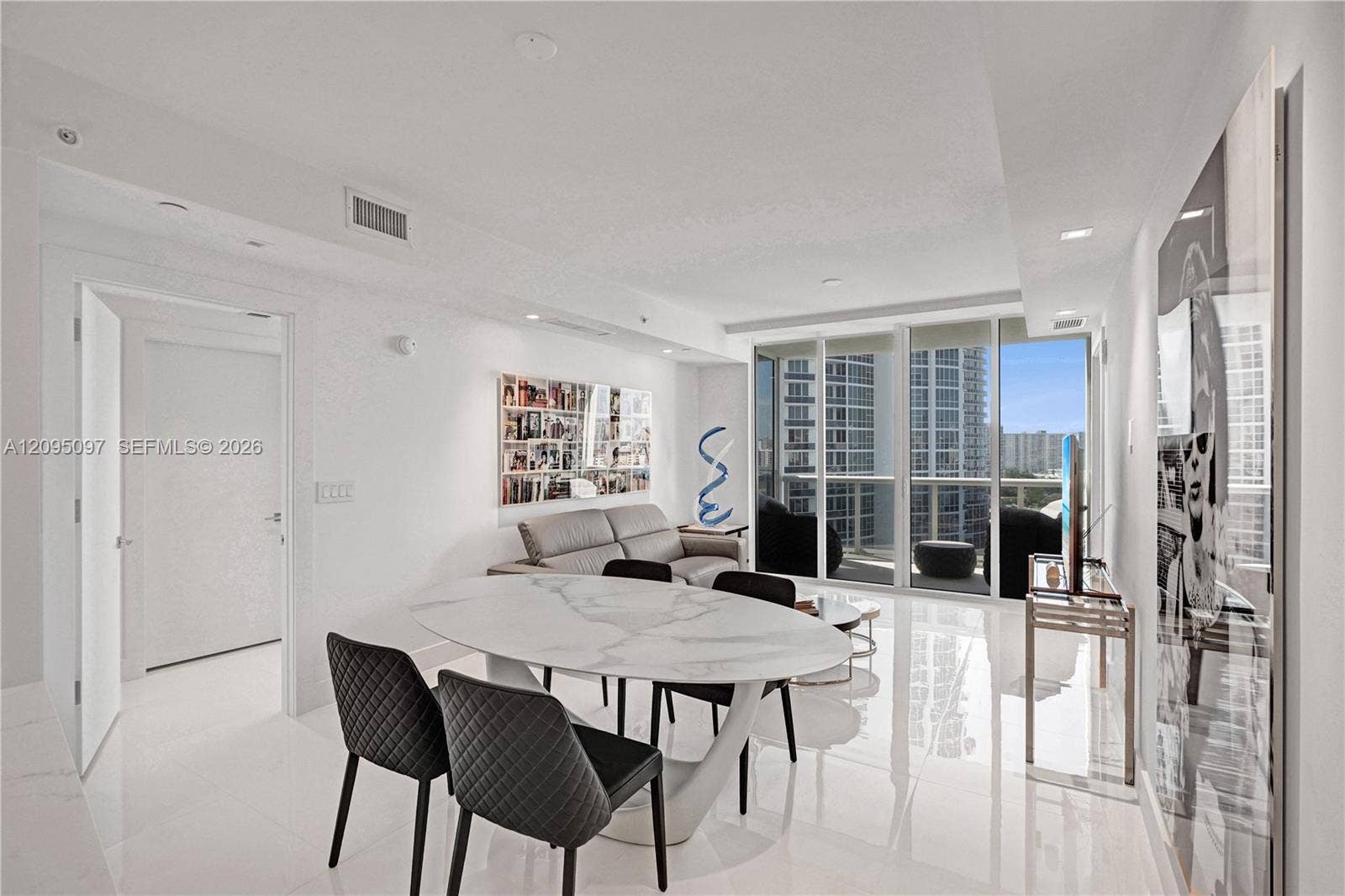 18201 Collins Avenue, #1407, Sunny Isles Beach, FL 33160 Open-concept living space featuring high-gloss tile flooring, recessed lighting, and floor-to-ceiling glass sliding doors
