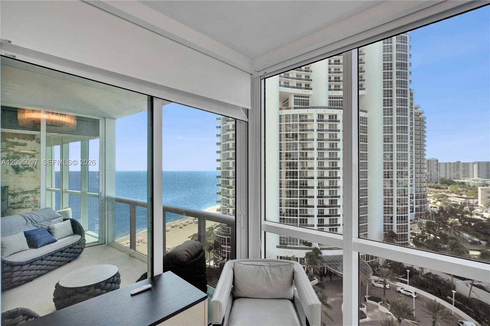 18201 Collins Avenue, #1407, Sunny Isles Beach, FL 33160 Floor-to-ceiling glass windows, expansive exterior balcony with glass railing, and coastal scenery
