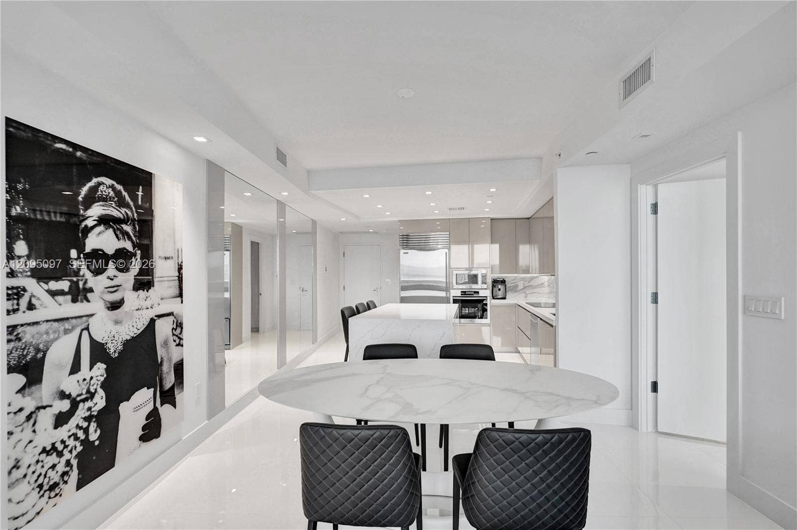 18201 Collins Avenue, #1407, Sunny Isles Beach, FL 33160 Open-concept kitchen featuring high-gloss cabinetry, a central island with stone-finish countertops, stainless steel appliances, recessed lighting, and polished stone flooring