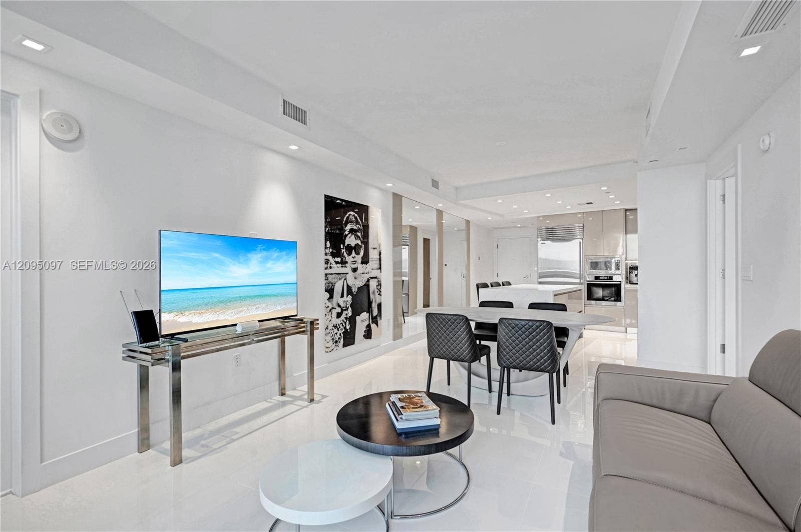 18201 Collins Avenue, #1407, Sunny Isles Beach, FL 33160 Open-concept living space featuring high-gloss flooring, recessed lighting, integrated ceiling speakers, and kitchen cabinetry with a reflective finish