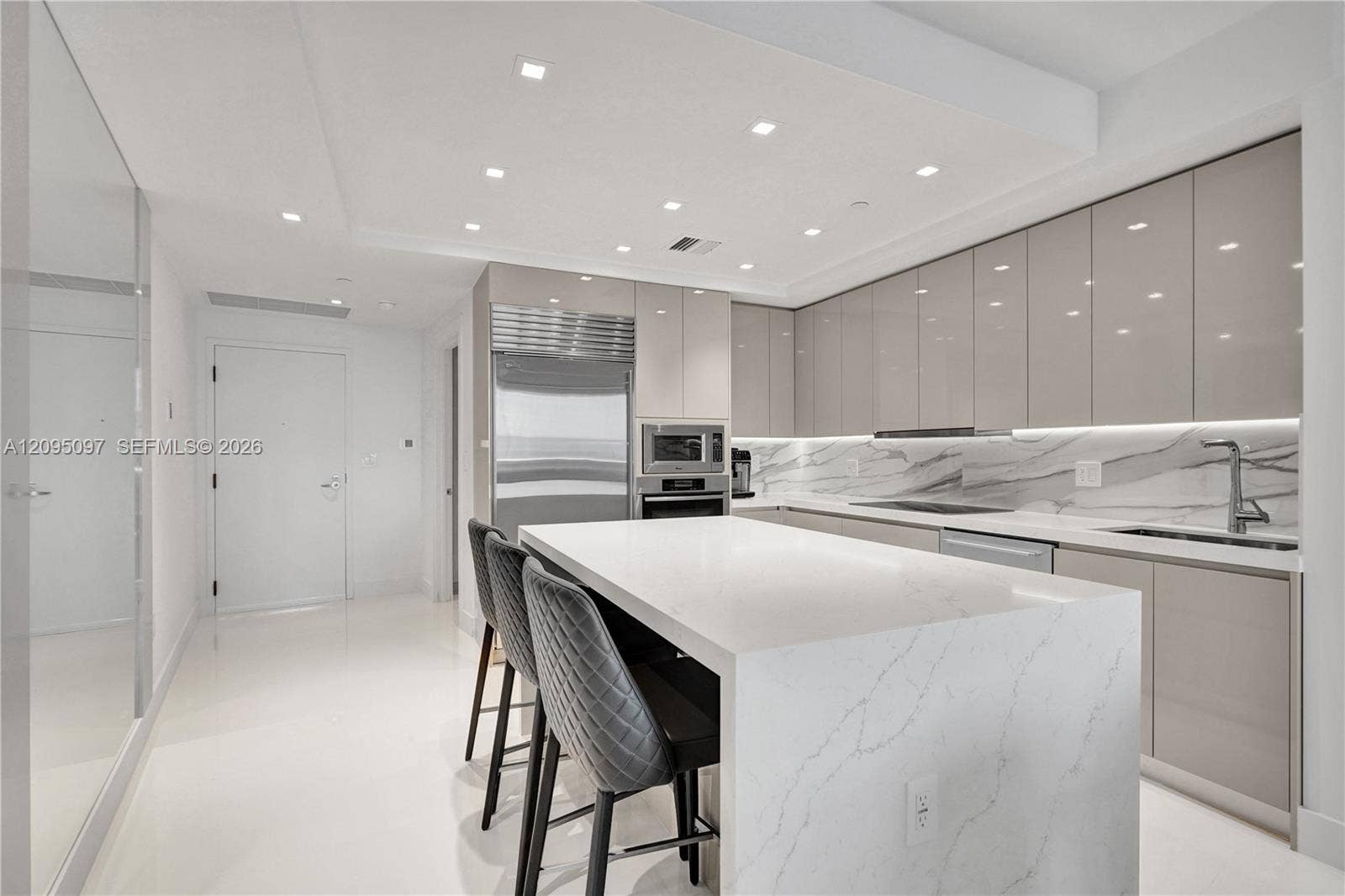 18201 Collins Avenue, #1407, Sunny Isles Beach, FL 33160 Kitchen featuring high-gloss cabinetry, stone countertops with waterfall edge island, integrated stainless steel appliances, and recessed ceiling lighting