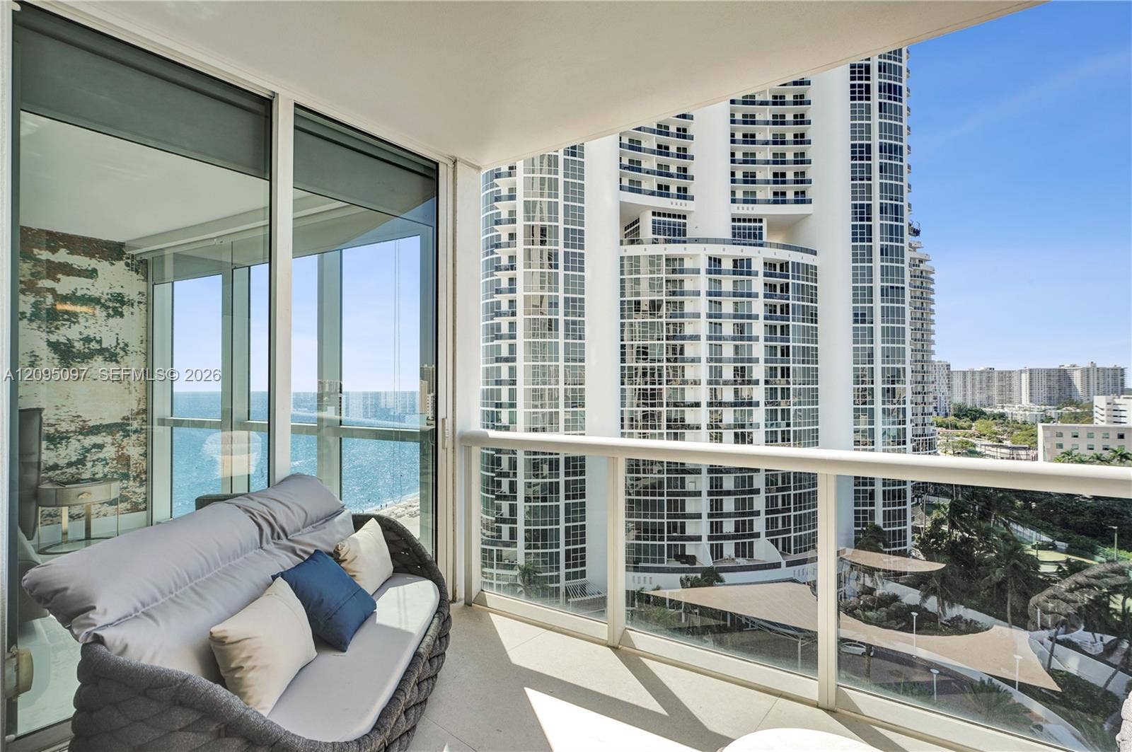 18201 Collins Avenue, #1407, Sunny Isles Beach, FL 33160 Private balcony featuring expansive floor-to-ceiling glass wall, sleek glass-panel railing, and durable tile flooring