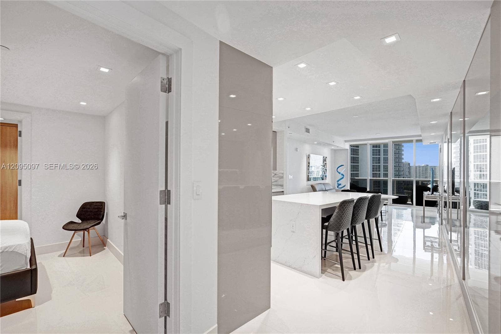 18201 Collins Avenue, #1407, Sunny Isles Beach, FL 33160 Kitchen island with waterfall countertop, recessed ceiling lighting, glossy wall paneling, polished flooring, and floor-to-ceiling windows