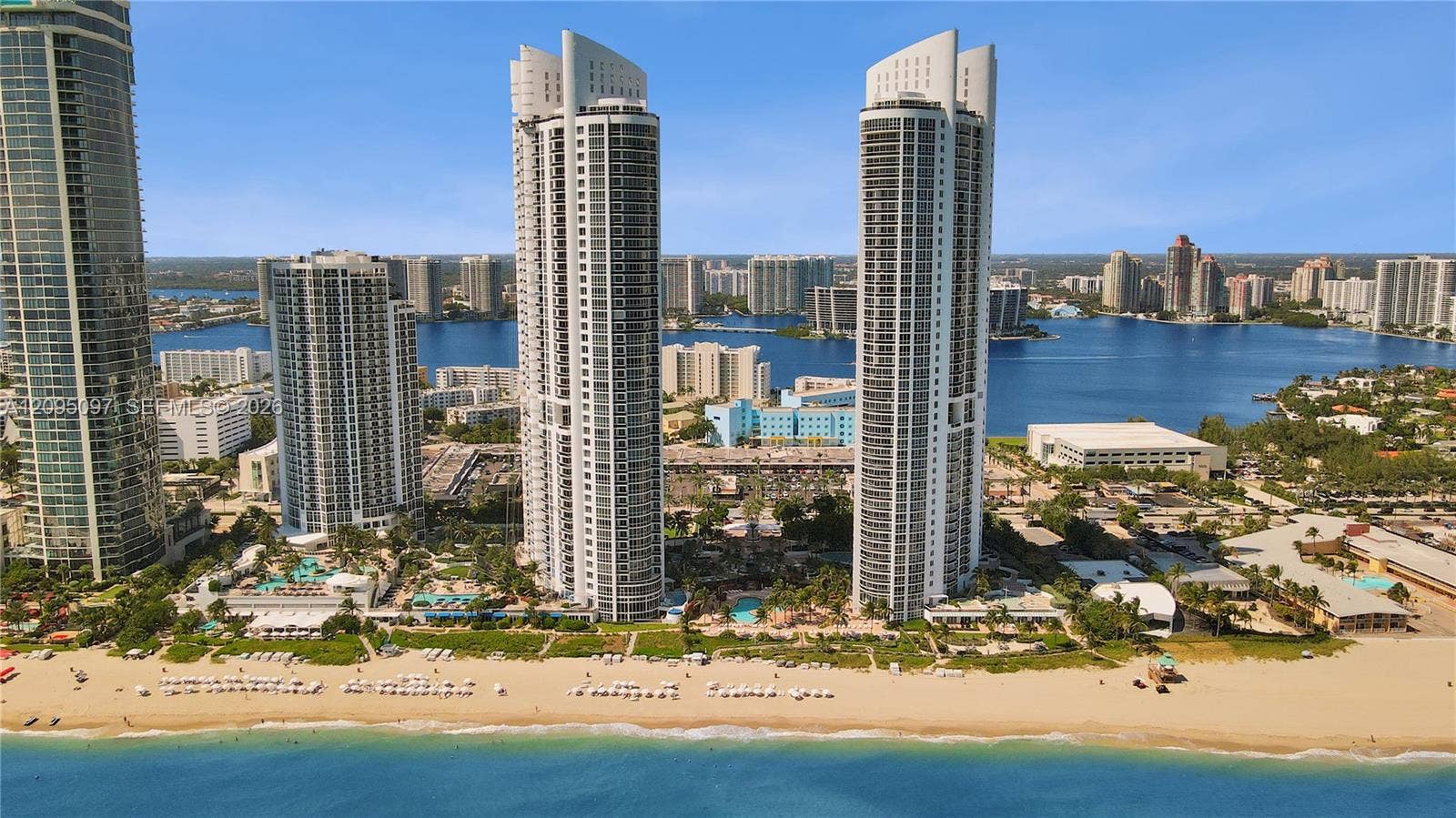 18201 Collins Avenue, #1407, Sunny Isles Beach, FL 33160 High-rise residential towers featuring glass-facade architecture, expansive balconies, direct waterfront access, and proximity to the coastline