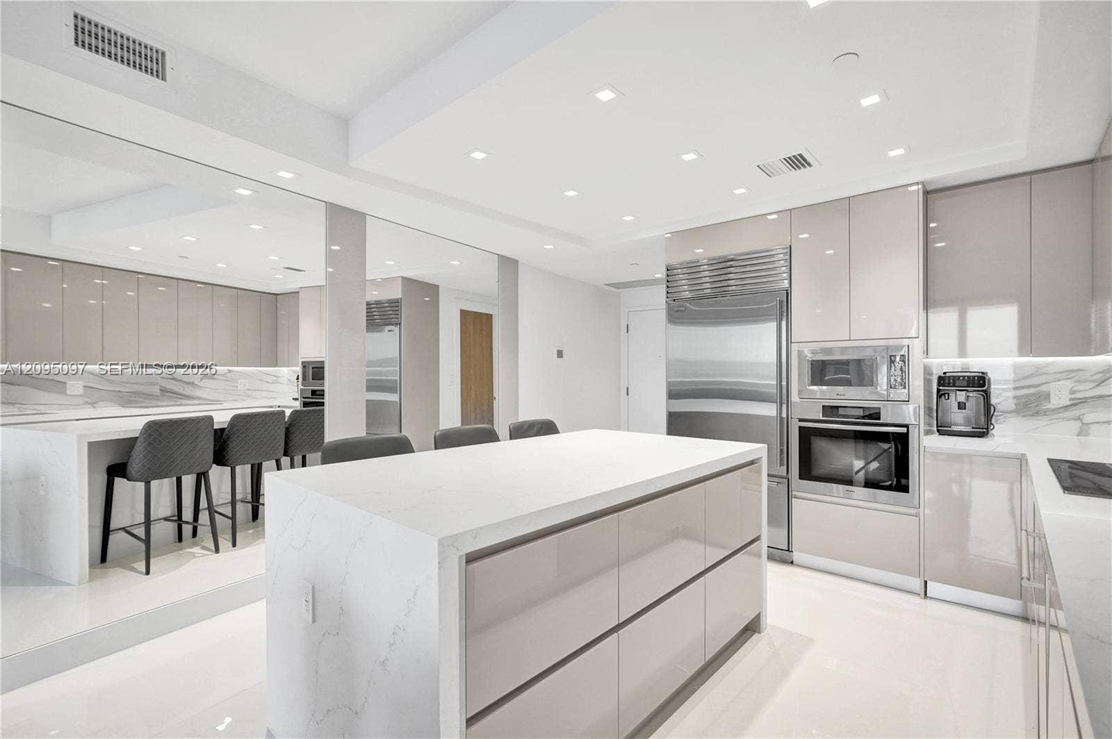 18201 Collins Avenue, #1407, Sunny Isles Beach, FL 33160 Modern kitchen featuring high-gloss cabinetry, stone-finish countertops with waterfall edge, integrated stainless steel appliances, and recessed ceiling lighting
