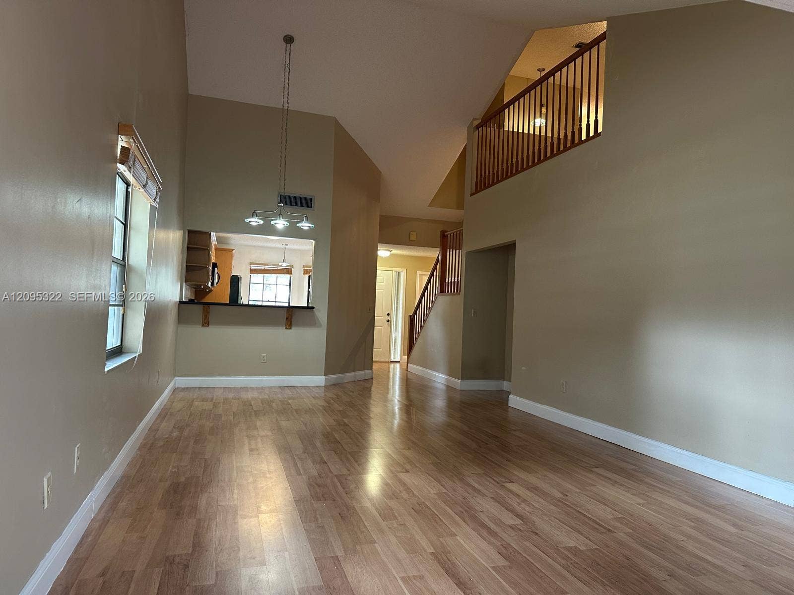 10061 SW 137th Place, Miami, FL 33186 Vaulted ceilings, wood-finish flooring, built-in breakfast bar, open-railing staircase, and multi-light pendant fixture