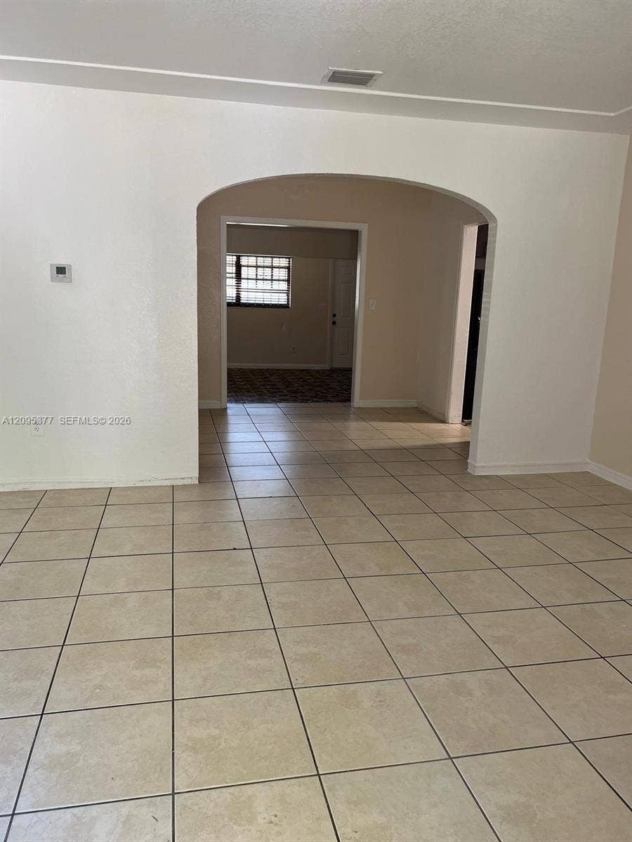 570 NW 41st Street, Miami, FL 33127 Neutral-toned tile flooring, distinctive arched architectural opening, and clean, light-colored walls