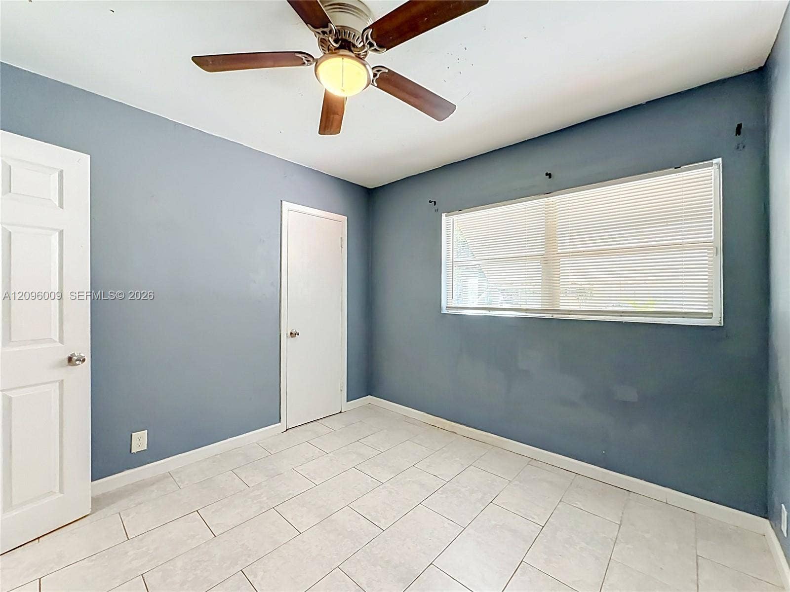1191 Alabama Avenue, Fort Lauderdale, FL 33312 Room featuring tile flooring, a central ceiling fan with an integrated light fixture, two panel-style doors, and a horizontal window with adjustable blinds