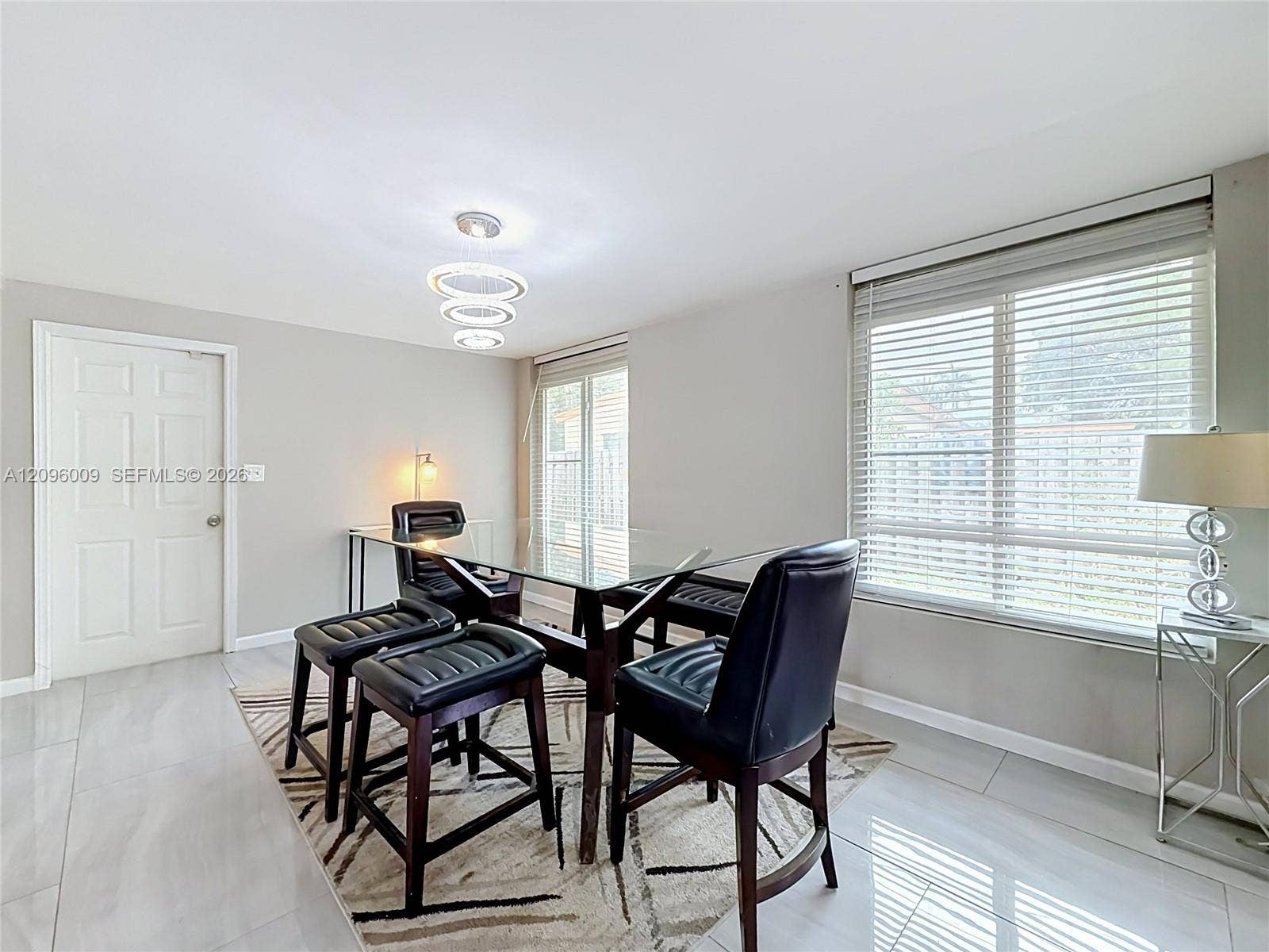 1191 Alabama Avenue, Fort Lauderdale, FL 33312 Multi-tiered circular pendant light, large-format tile flooring, and oversized windows with horizontal blinds