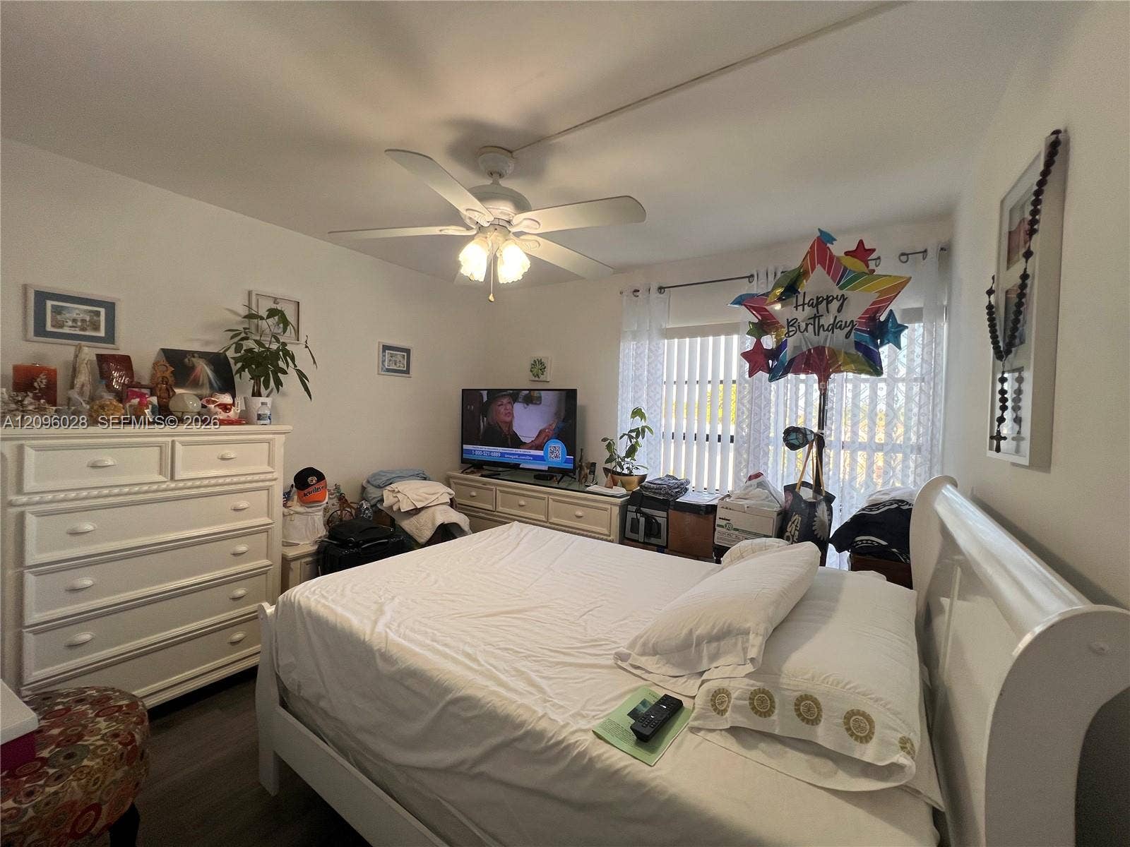 6300 SW 138th Court, #405, Miami, FL 33183 Room featuring wood-finish flooring, a white ceiling fan with integrated lighting, and vertical window blinds