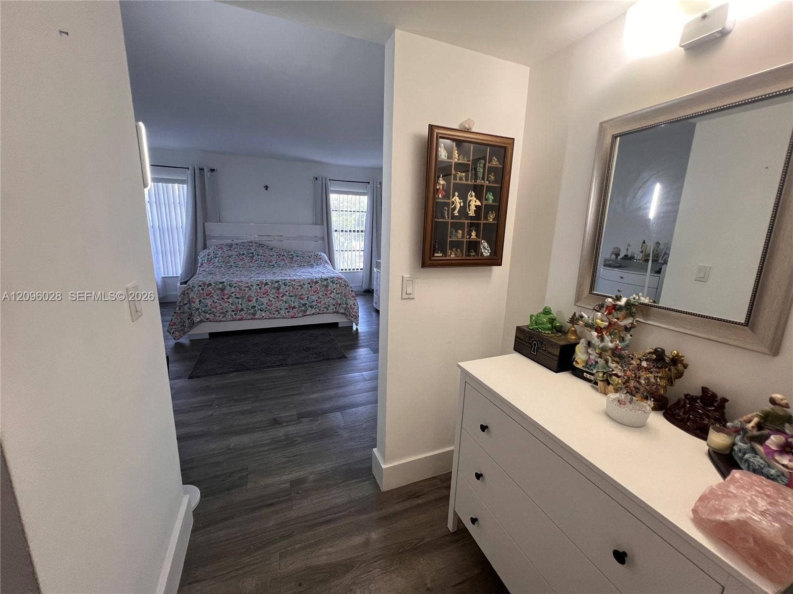 6300 SW 138th Court, #405, Miami, FL 33183 Wood-finish flooring throughout, wall-mounted rectangular mirror with a metallic frame, and overhead lighting fixtures