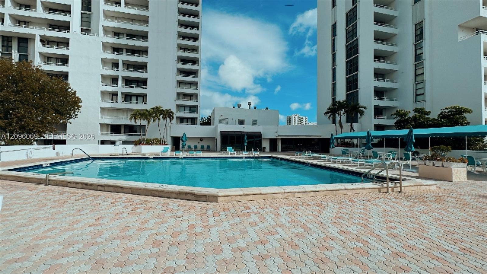 20355 NE 34th Court, #1925, Aventura, FL 33180 Swimming pool featuring a paved deck, surrounded by multi-story residential buildings with balconies