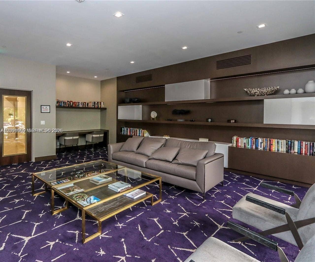 20355 NE 34th Court, #1925, Aventura, FL 33180 Custom wall-to-wall shelving with integrated cabinetry, built-in desk area, recessed lighting, and glass-paneled entry door