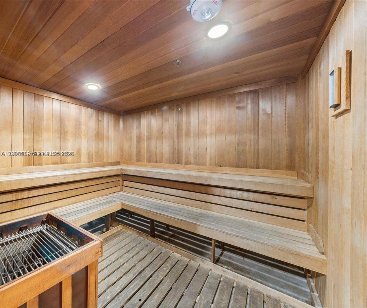 20355 NE 34th Court, #1925, Aventura, FL 33180 Sauna featuring tongue-and-groove wood paneling, multi-level built-in wood benches, slatted wood flooring, and a dedicated heating unit