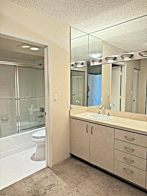 20355 NE 34th Court, #1925, Aventura, FL 33180 Bathroom vanity featuring solid-surface countertop, integrated oval sink, multi-drawer cabinetry, and full-width vanity mirror with integrated light fixture