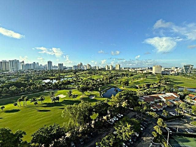 20355 NE 34th Court, #1925, Aventura, FL 33180 Expansive golf course grounds featuring manicured turf, multiple water hazards, mature palm trees, and an urban skyline backdrop