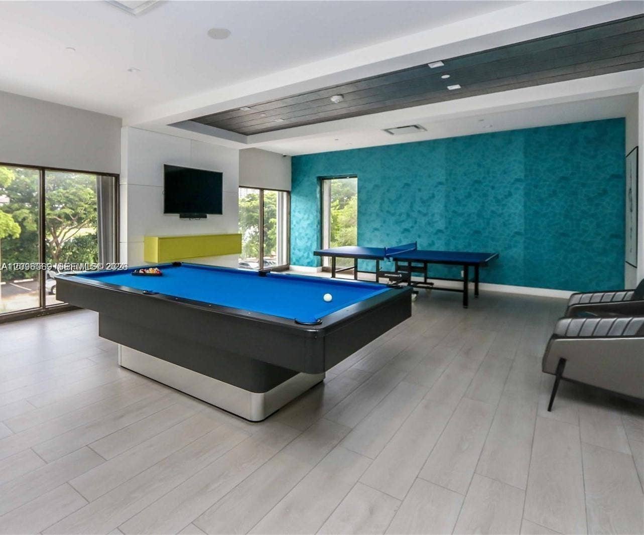 20355 NE 34th Court, #1925, Aventura, FL 33180 Recessed ceiling featuring dark-toned plank detailing, wood-finish flooring, floor-to-ceiling glass windows, and a textured teal accent wall