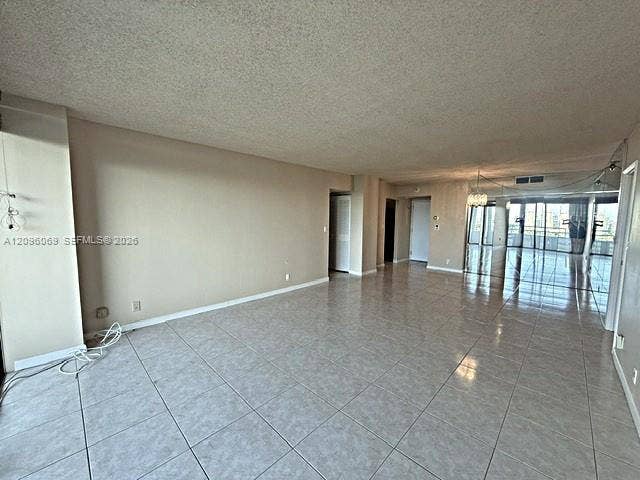 20355 NE 34th Court, #1925, Aventura, FL 33180 Open-concept interior featuring light-toned tile flooring, recessed lighting, and expansive floor-to-ceiling glass sliding doors