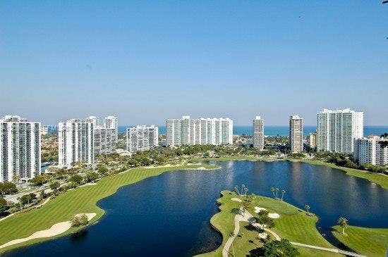 20355 NE 34th Court, #1925, Aventura, FL 33180 Panoramic aerial perspective featuring a golf course, expansive lake, and high-rise skyline