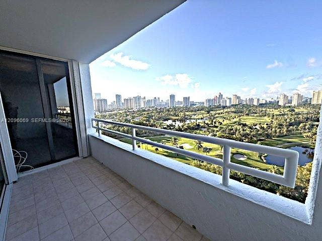 20355 NE 34th Court, #1925, Aventura, FL 33180 Private balcony featuring a tiled floor and a horizontal metal railing, overlooking a golf course and skyline