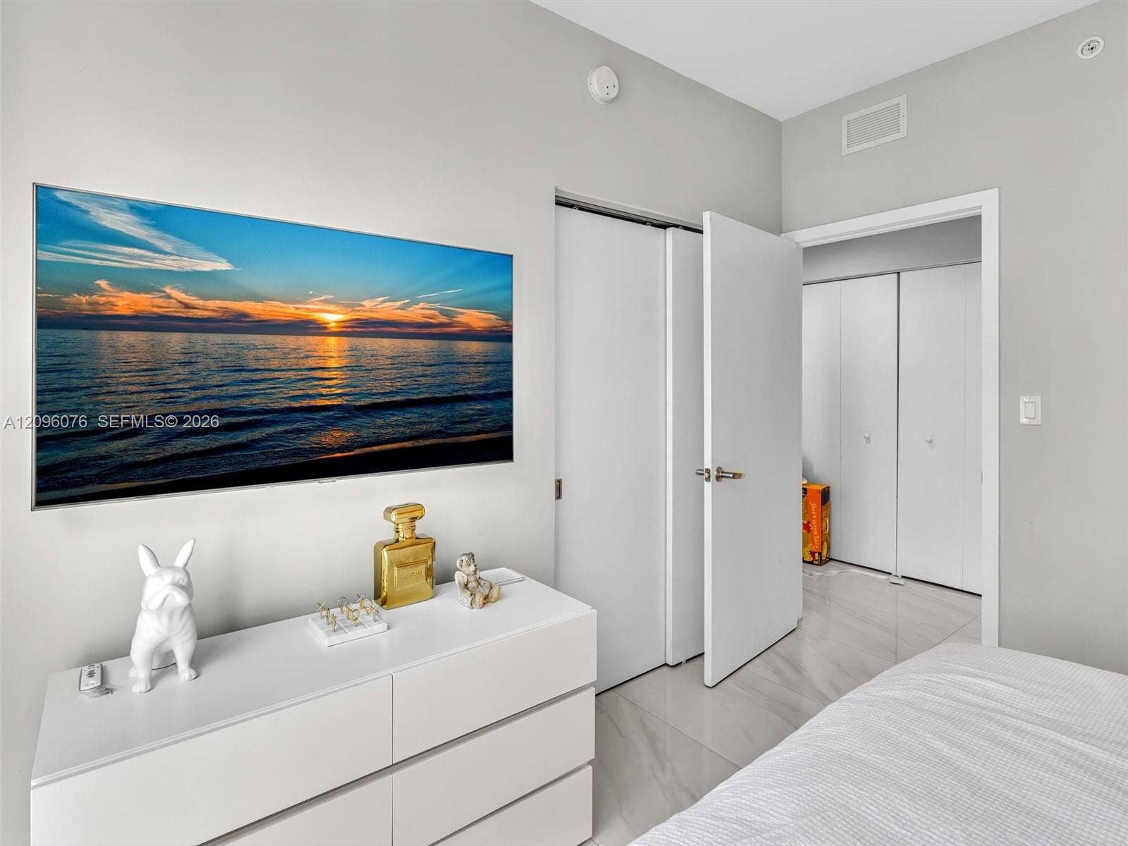 16385 Biscayne Boulevard, #1101, North Miami Beach, FL 33160 Neutral wall palette, polished stone-finish flooring, and multiple sets of white bi-fold closet doors