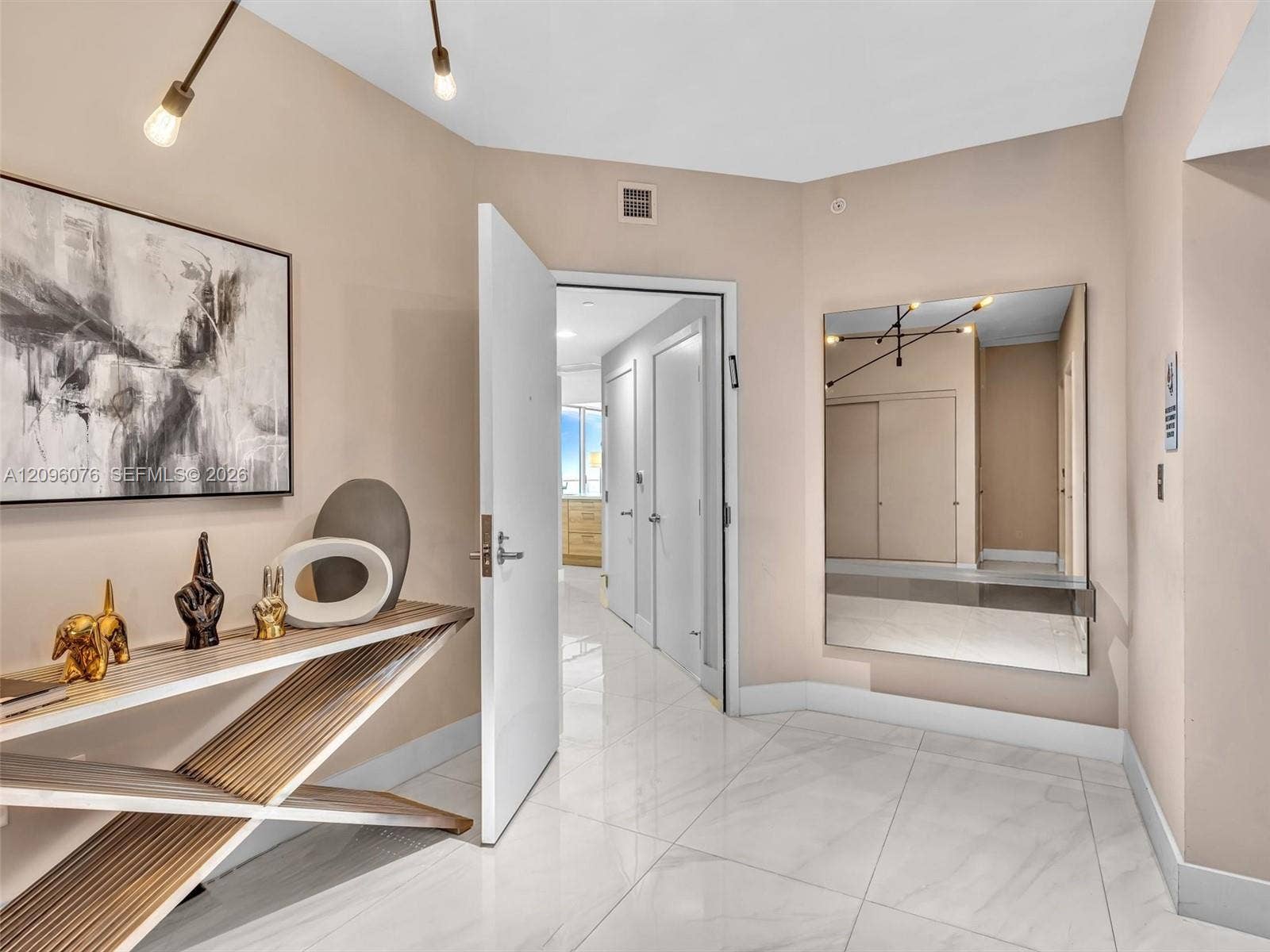16385 Biscayne Boulevard, #1101, North Miami Beach, FL 33160 Foyer featuring polished stone-finish flooring, a wall-mounted rectangular mirror, and modern multi-arm light fixture