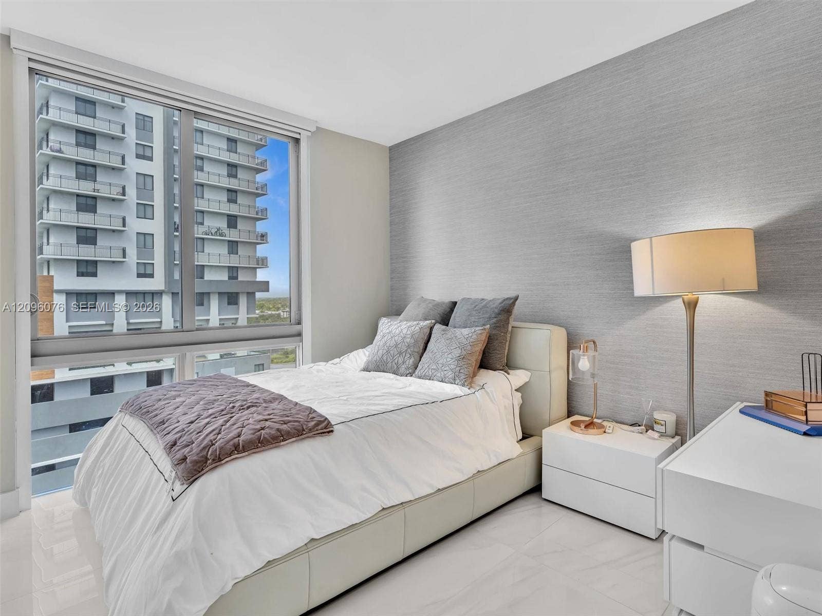 16385 Biscayne Boulevard, #1101, North Miami Beach, FL 33160 Floor-to-ceiling windows, textured accent wall, and polished tile flooring