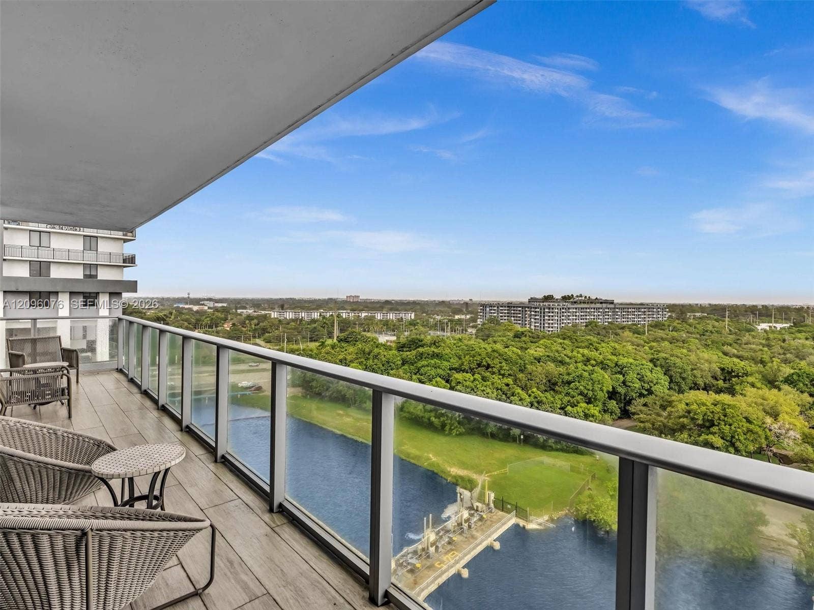 16385 Biscayne Boulevard, #1101, North Miami Beach, FL 33160 Covered balcony featuring wood-finish tile flooring, glass panel railings, and metal framing