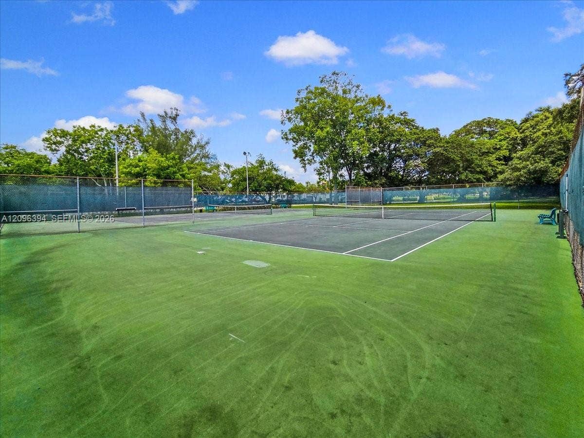 1830 Sabal Palm Drive, #105, Davie, FL 33324 Private tennis court featuring a fenced perimeter, hard surface, and integrated net systems