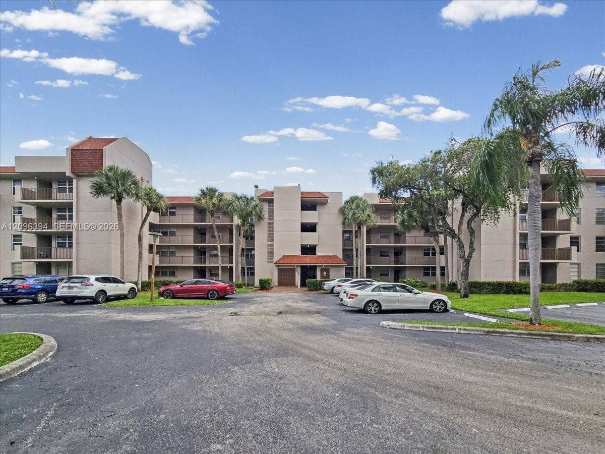 1830 Sabal Palm Drive, #105, Davie, FL 33324 Multi-story building exterior featuring a tiled roof, stucco facade, and recessed private balconies