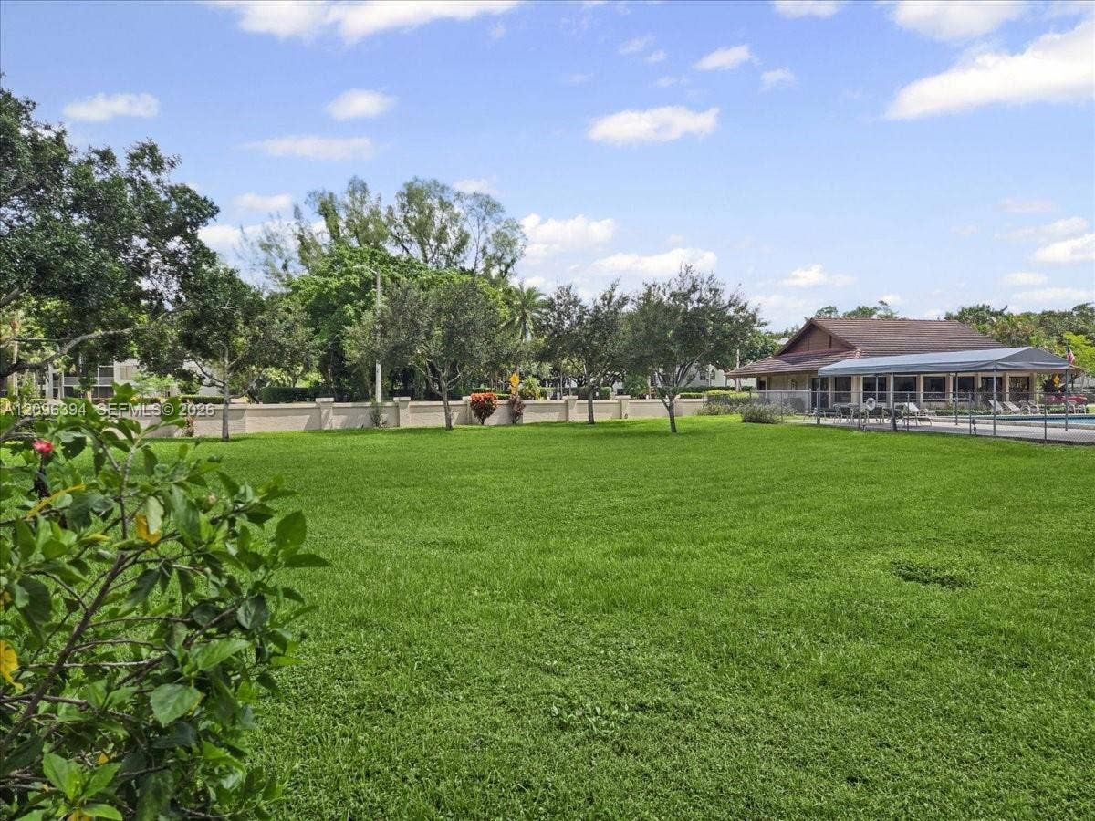 1830 Sabal Palm Drive, #105, Davie, FL 33324 Expansive lawn featuring perimeter wall enclosure, mature landscaping, and a covered pavilion structure