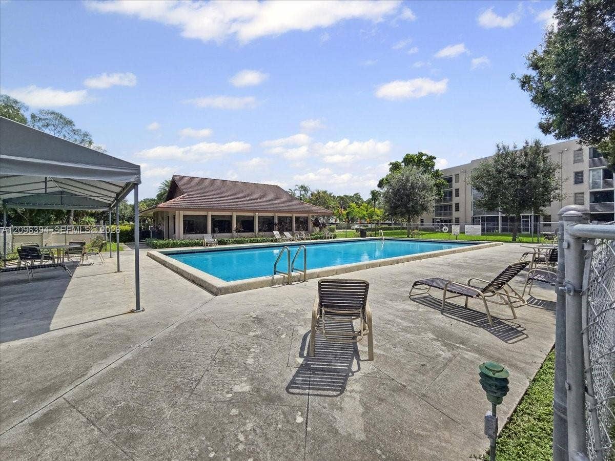 1830 Sabal Palm Drive, #105, Davie, FL 33324 Community swimming pool featuring a concrete deck, covered seating area, and clubhouse