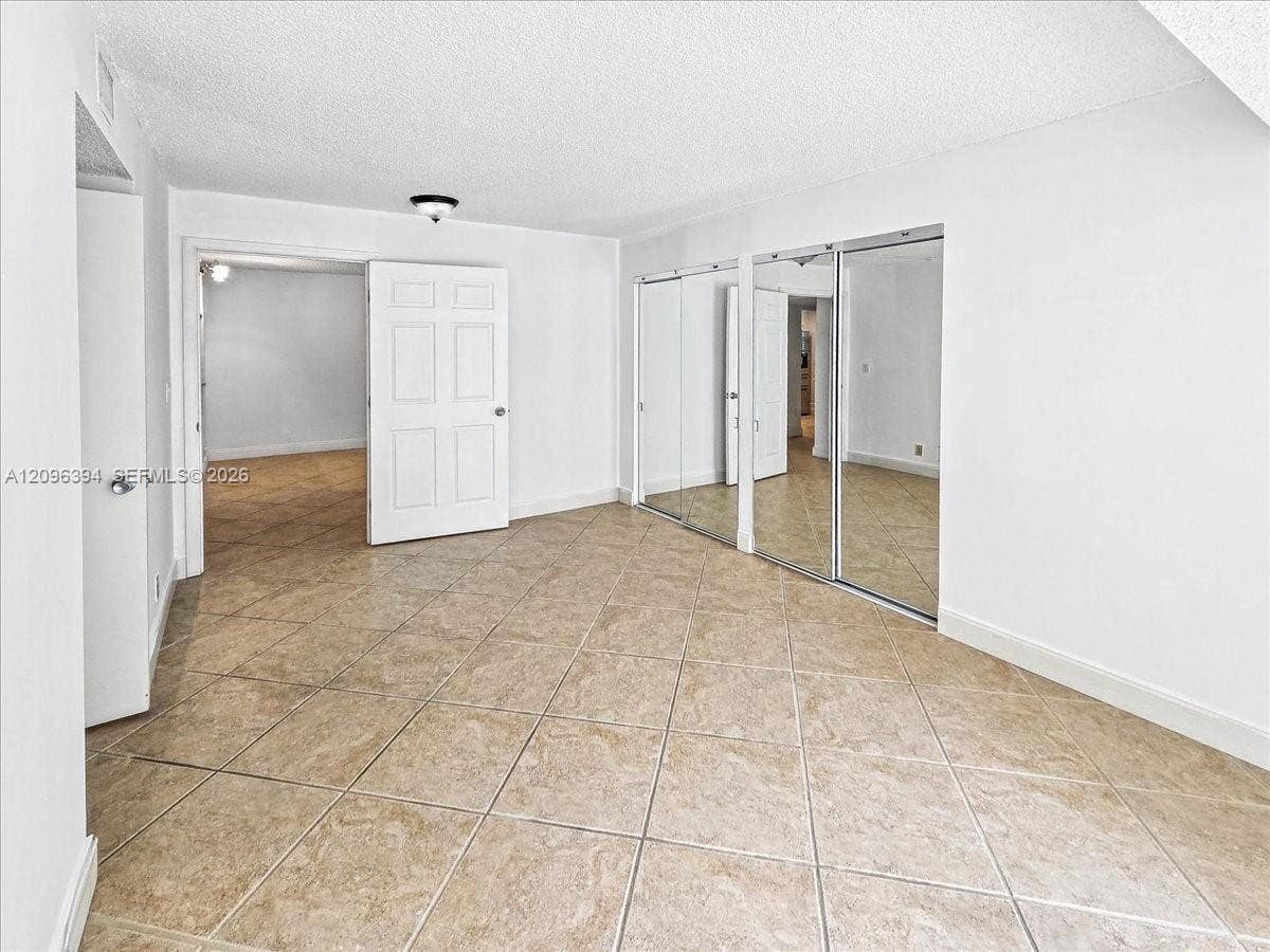 1830 Sabal Palm Drive, #105, Davie, FL 33324 Ceramic tile flooring laid in a diagonal pattern, full-height mirrored sliding closet doors, and solid-core interior passage doors