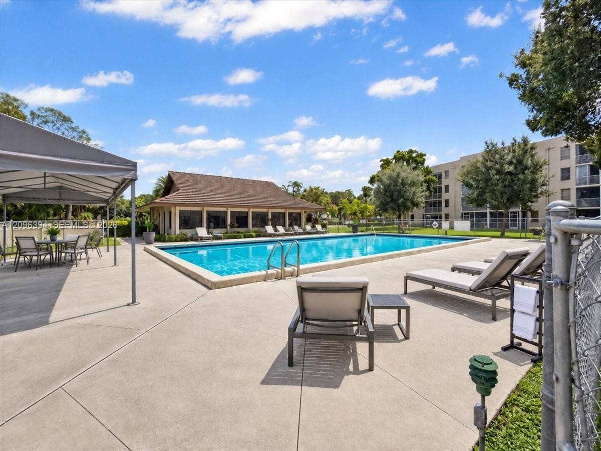 1830 Sabal Palm Drive, #105, Davie, FL 33324 Outdoor swimming pool featuring a concrete deck, covered pavilion, and metal perimeter fencing