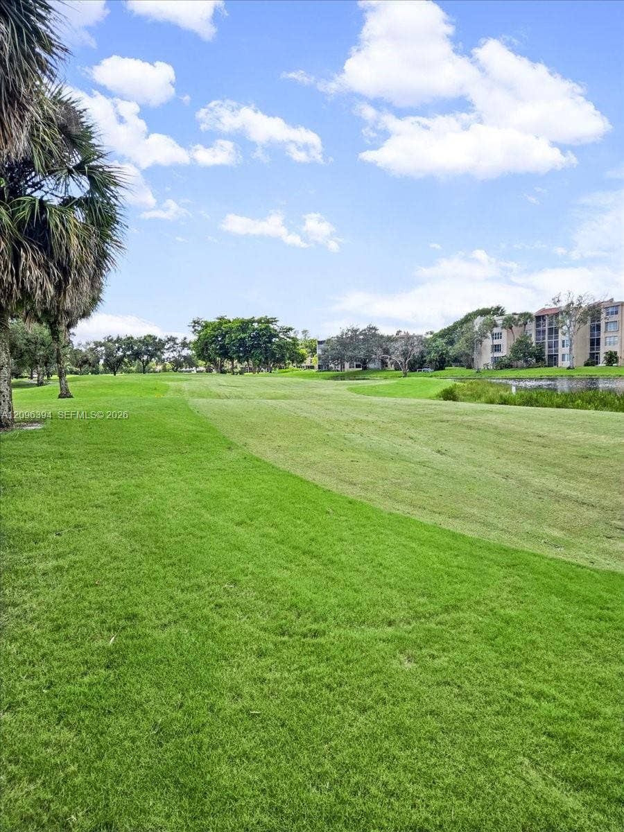 1830 Sabal Palm Drive, #105, Davie, FL 33324 Expansive green space featuring mature palm trees, manicured turf, and a natural water feature